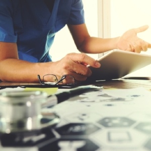 Medicine doctor hand working with modern computer and digital tablet computer and medical diagram with his team on wooden desk as medical concept-770530-edited.jpeg